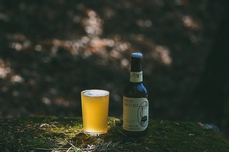 苔むした地面に置かれたクラフトビールとボトル