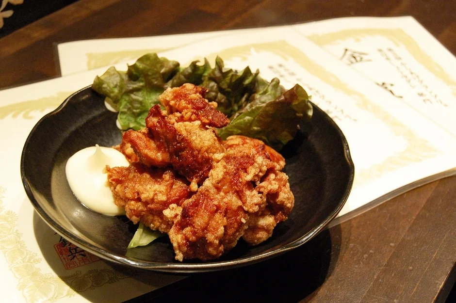 黒い皿に盛り付けられた鶏のから揚げ