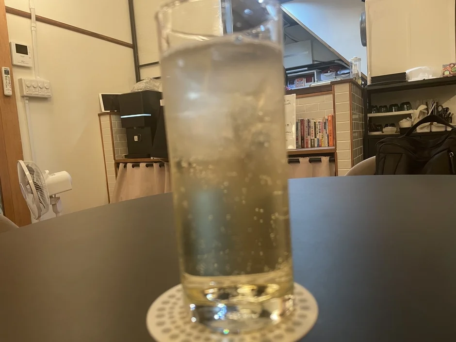 テーブルに置かれた氷入りの炭酸飲料のグラス