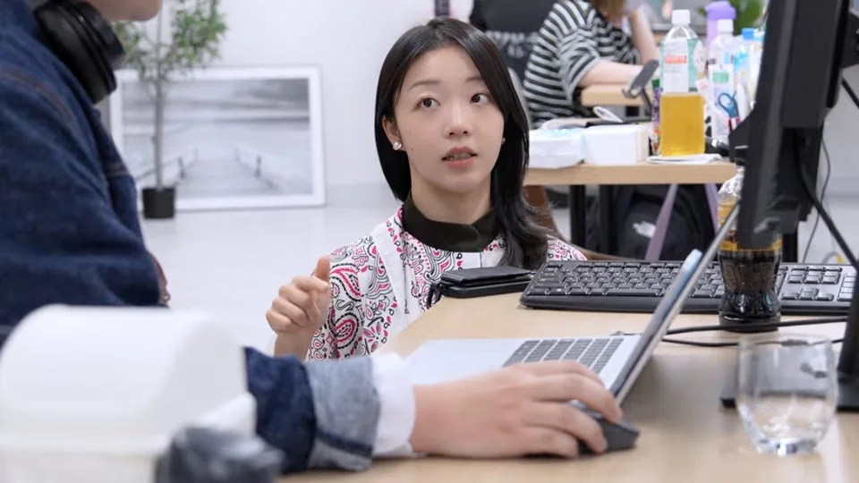 オフィスで働く人々が会話している様子