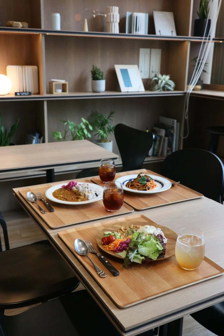 カフェ店内の食事風景、本や植物が飾られた落ち着いた雰囲気