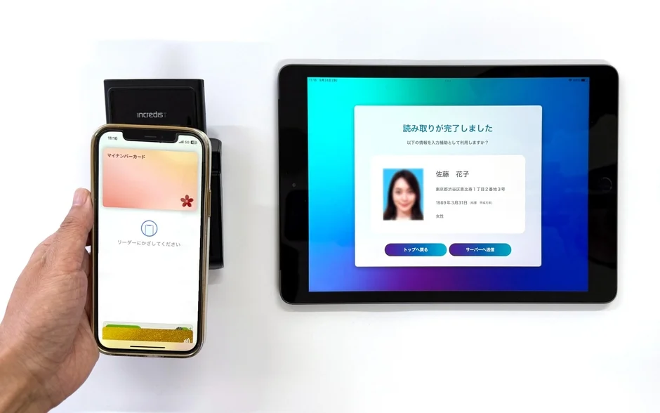 マイナンバーカードをスマートフォンにかざす様子