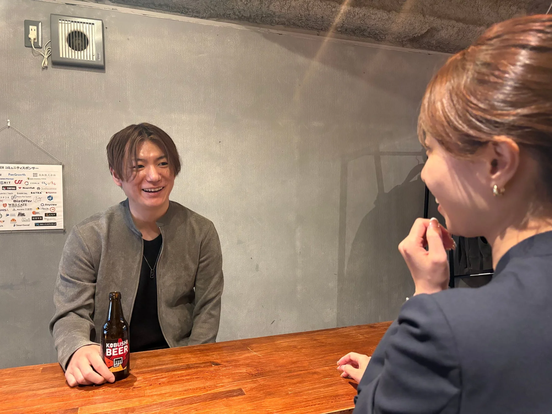 木製カウンターで会話する男女