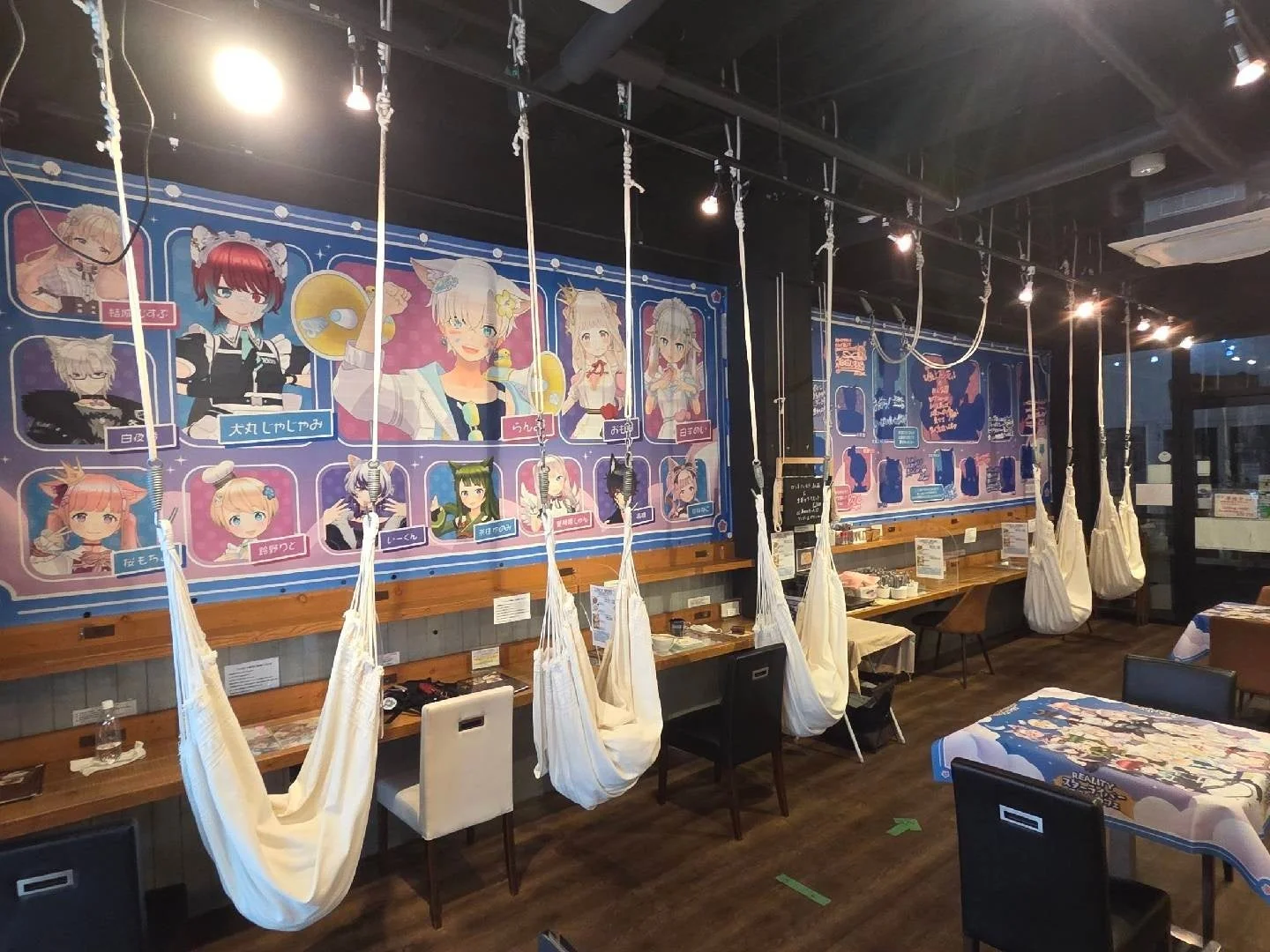 REALITYスターライバーコラボカフェの店内風景（キャラクターポスターとハンモックチェア）