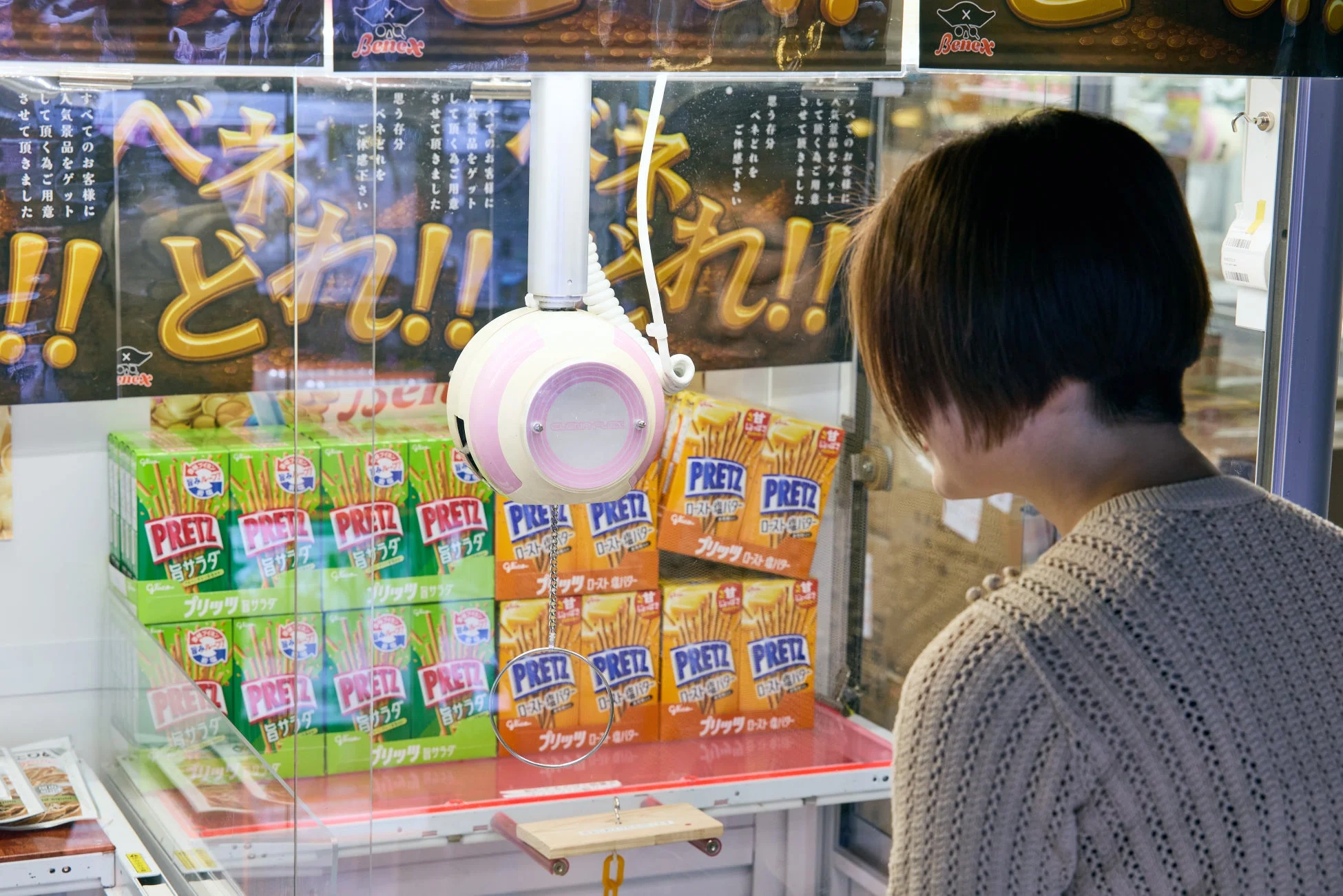 女性がプリッツのクレーンゲームをプレイ