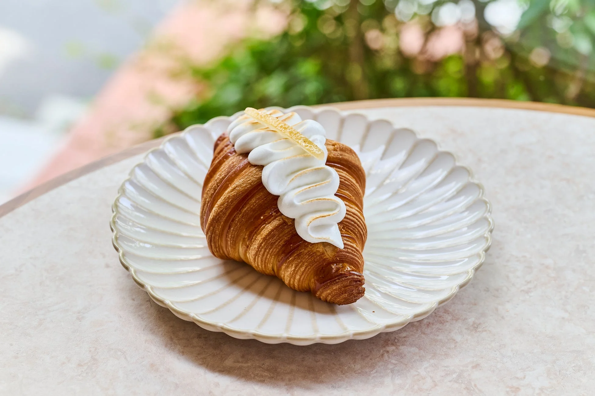 白いメレンゲとレモンピールが乗った焼きたてのクロワッサン