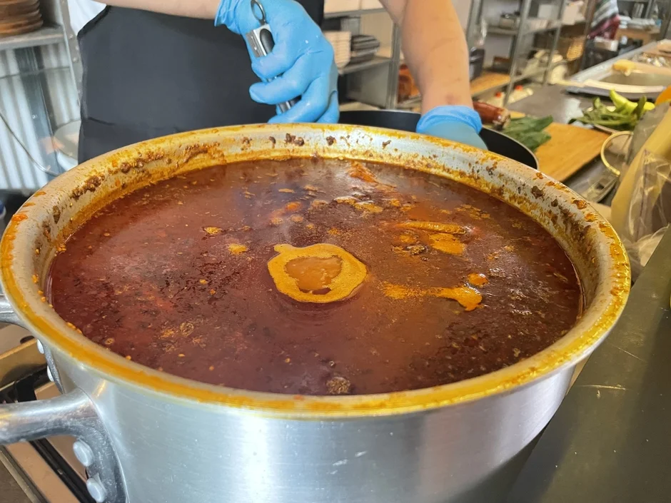 鍋で煮込み料理を作る料理人