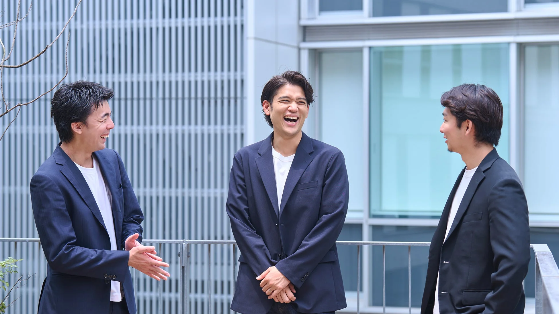 男性3人が屋外で会話
