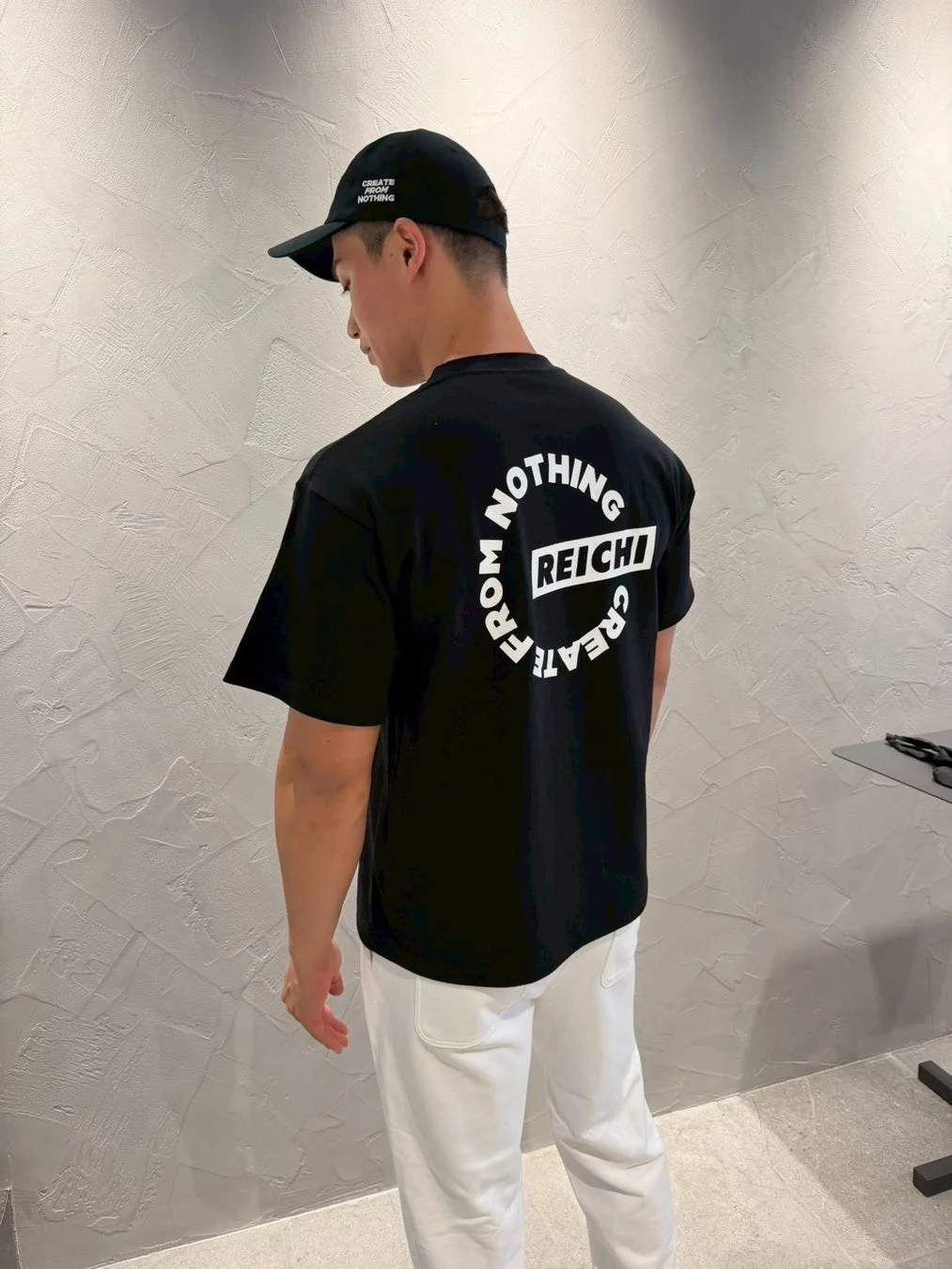 REICHIロゴ入りTシャツを着用した男性