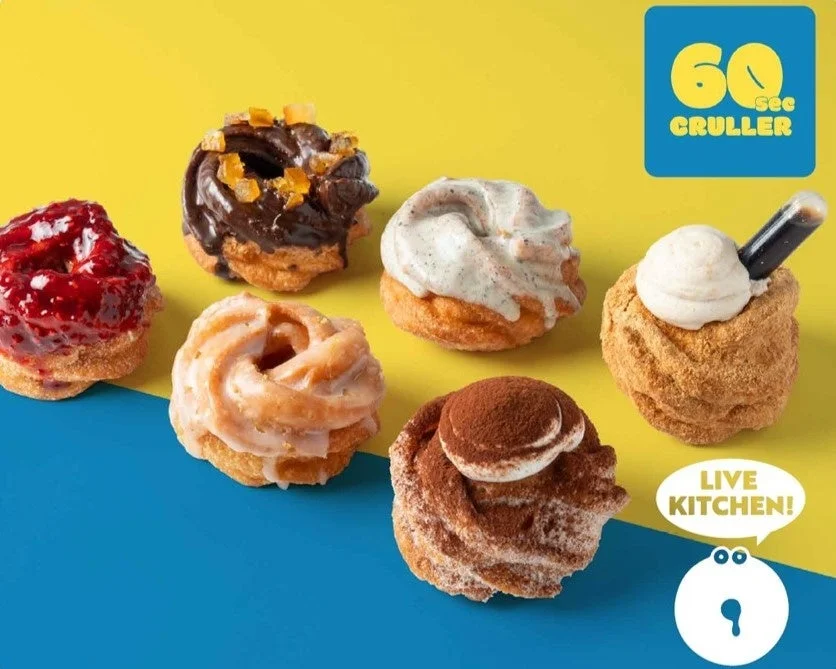 「60 Sec CRULLER」と書かれた、様々なフレーバーのフレンチクルーラーが並んだカラフルな画像です。チョコレート、ベリー、ティラミスなど、個性豊かなドーナツが食欲をそそります。