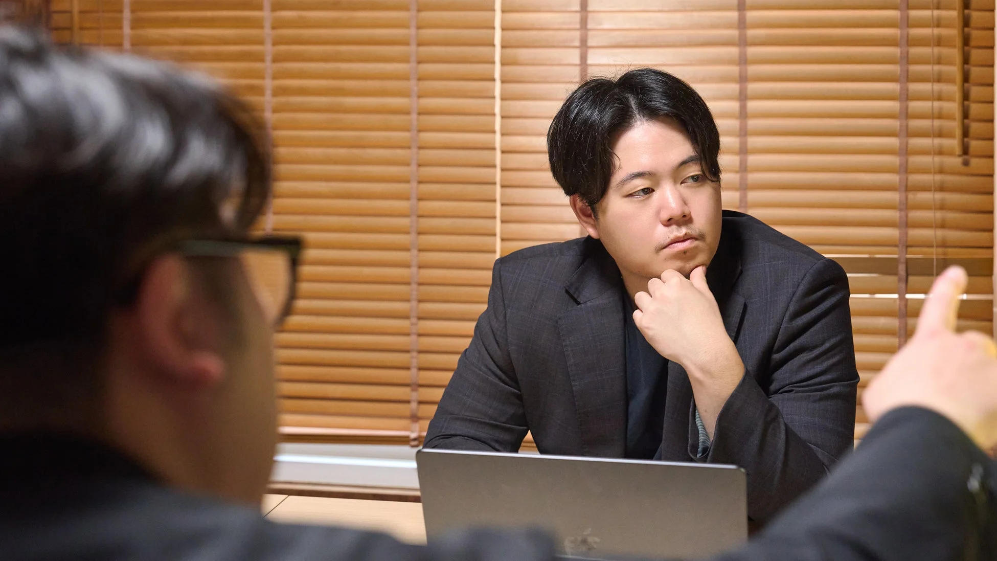 ビジネスシーンで男性二人が向かい合って話している