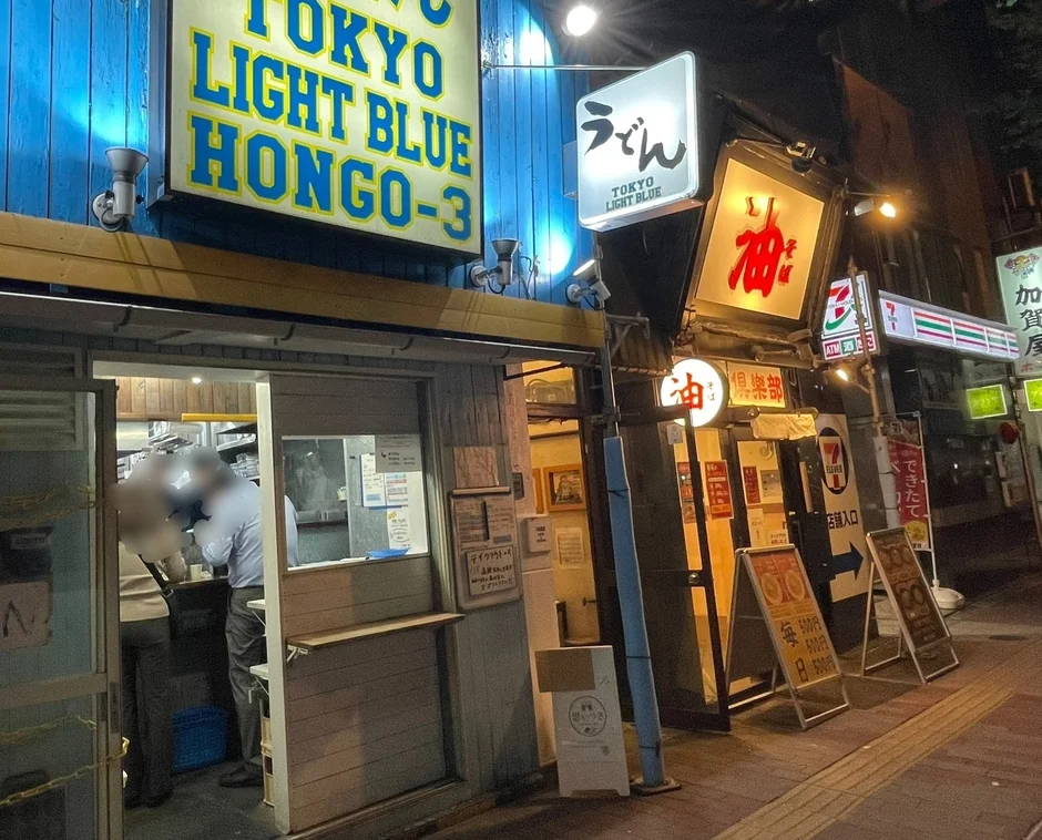 夜の日本の街角に立つ飲食店