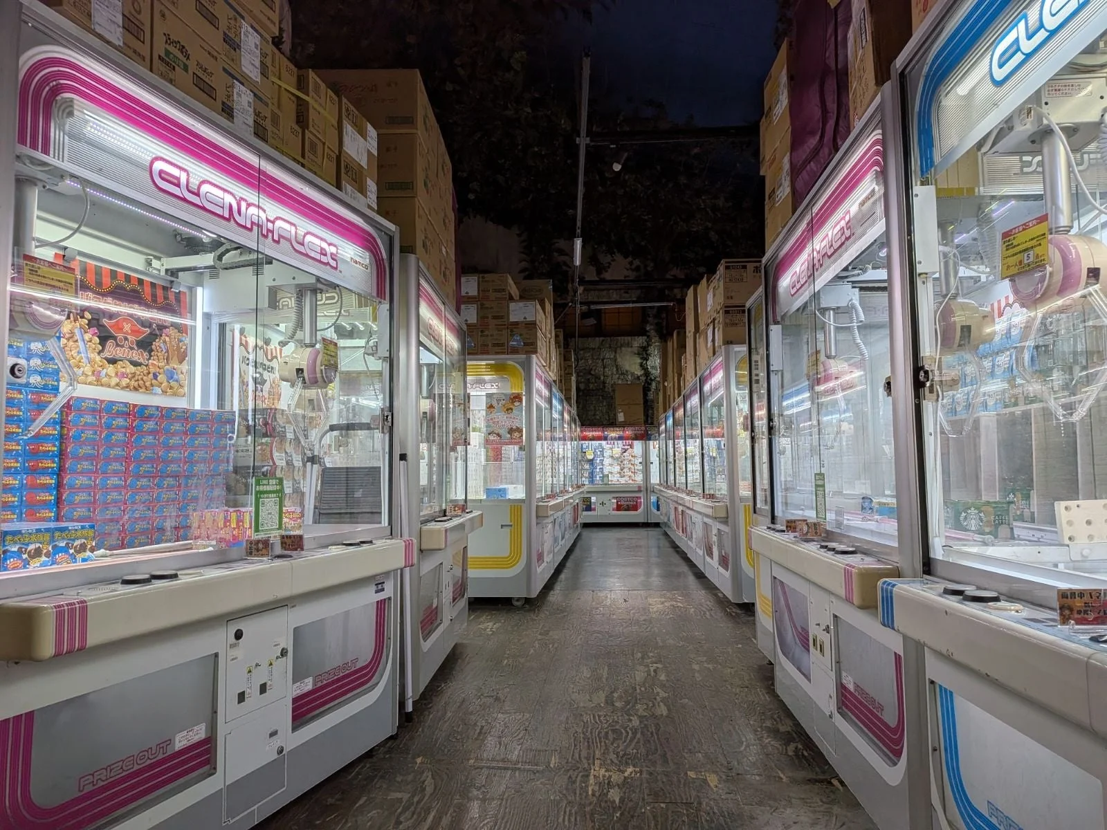 クレーンゲームが並ぶ通路、倉庫のような雰囲気
