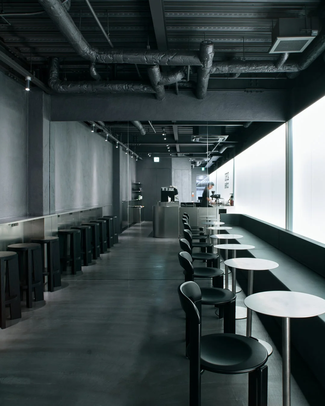 暗いトーンで統一されたモダンなカフェの店内