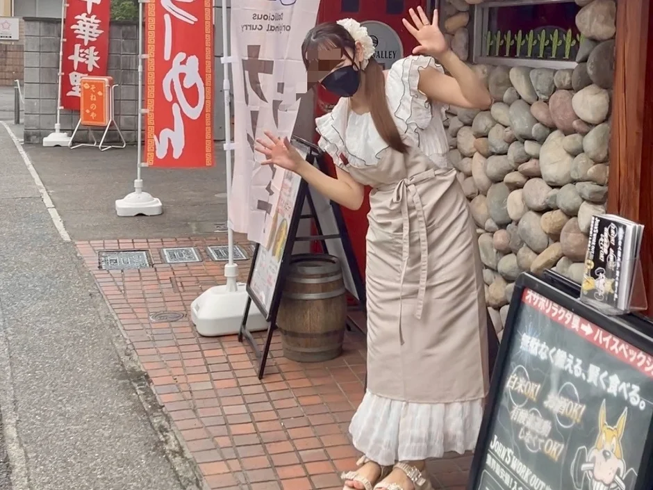 飲食店の前でポーズをとる女性と看板