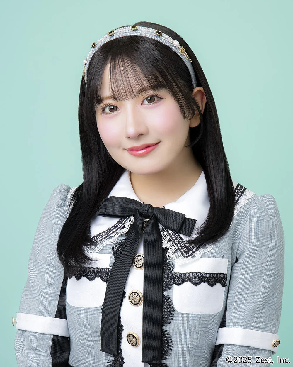 ライトグリーンの背景に、黒髪ロングヘアの女性が優しい笑顔を浮かべている