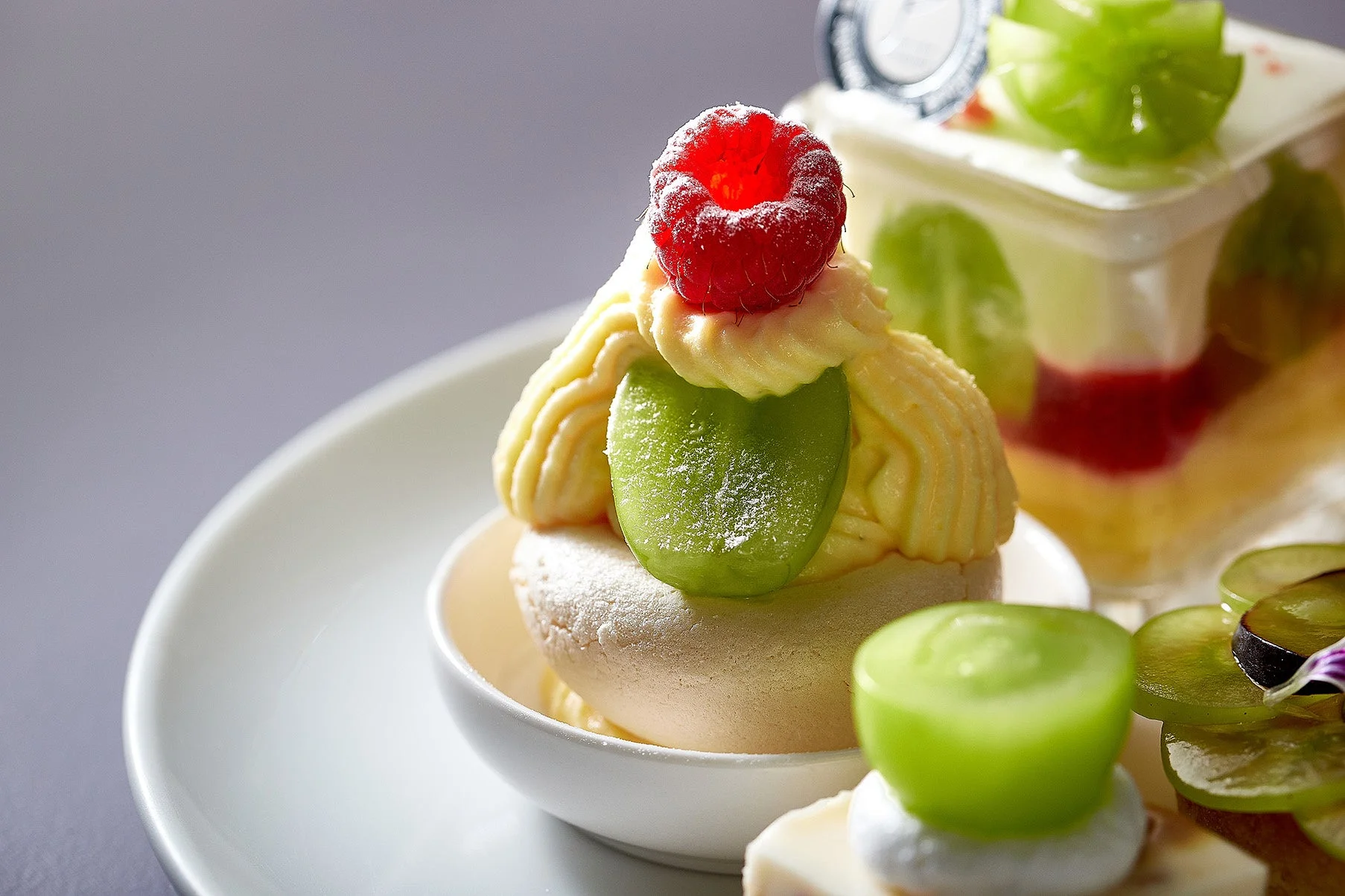 ラズベリーが乗ったクリームたっぷりのケーキとぶどうを使ったゼリー