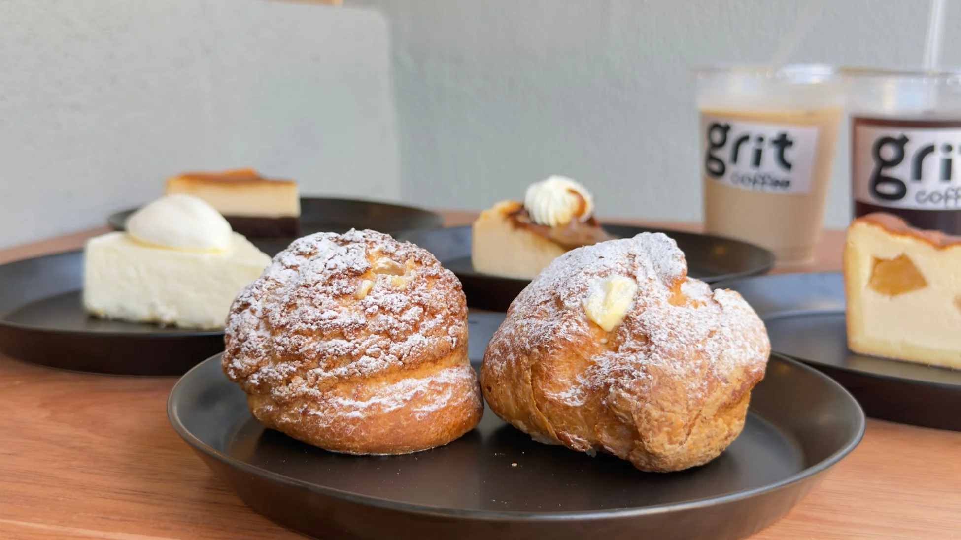 シュークリームやケーキ、アイスコーヒーが並ぶカフェのテーブル