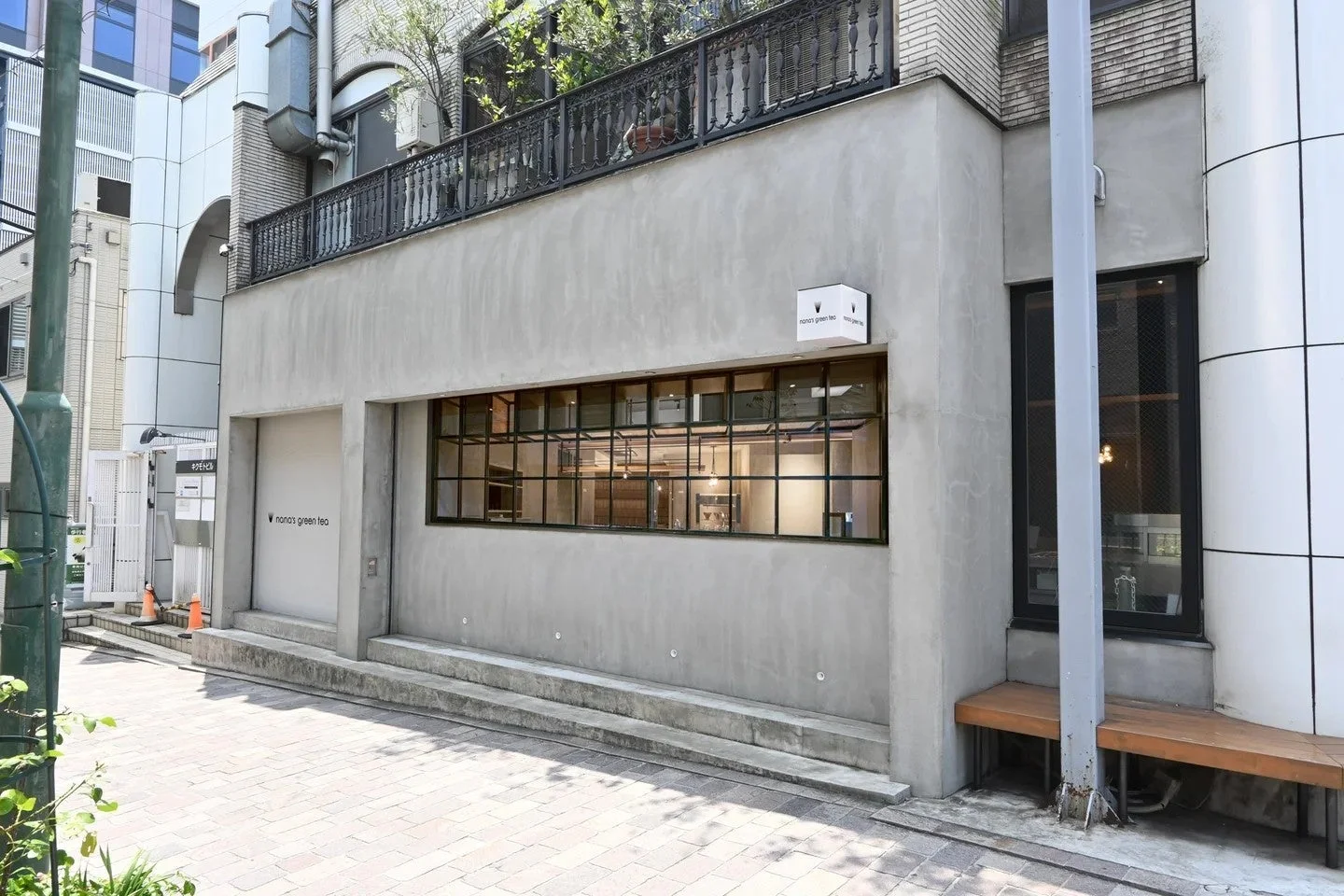 モダンなコンクリート造りの建物で、「nana's green tea」という店舗の外観