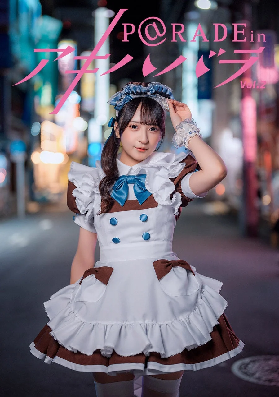 夜の街を背景に、可愛らしいメイド服を着た若い女性がポーズをとっています。