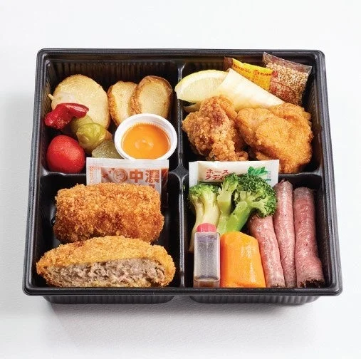 黒い容器に詰められた、揚げ物、肉料理、野菜など多種多様なおかずが入った豪華な弁当